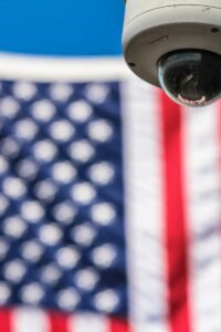 Surveillance camera focusing on security with American flag backdrop.